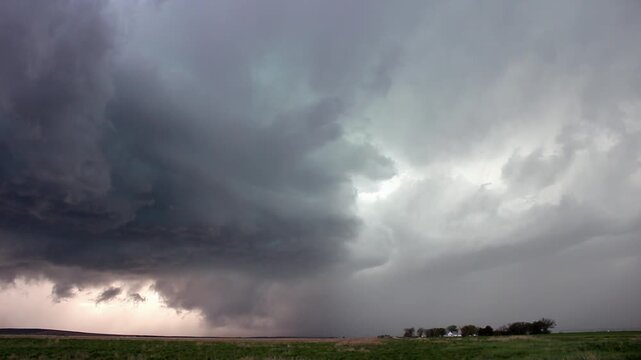 A severe storm with a wall cloud gathers strength as it dumps rain and hail over the rural countryside in this time lapse footage.