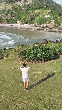 Ponta das Campanhas, Armacao in Florianopolis. A man walks across the island among the rocks. Aerial view.