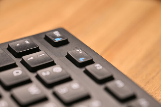Side Angled Top View Macro Close-Up Black Computer Keyboard Highlighting F1 Function Key on Blurred Tech Background