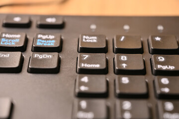 Obraz premium Minimal Black Keyboard Macro Composition Highlighting 7 and Home Keys on Numeric Keypad in Soft Focus Angled Top View