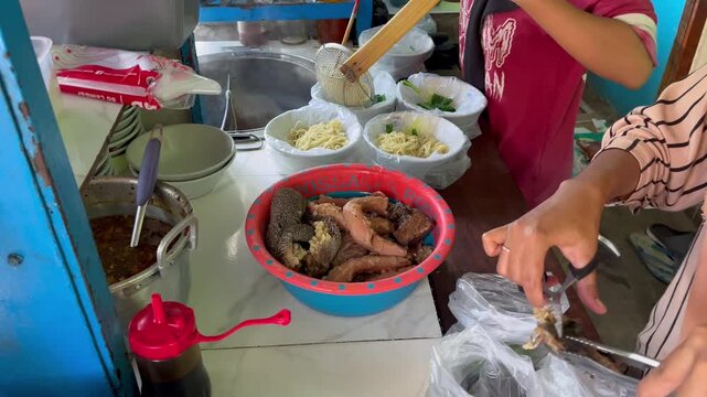Indonesian street food vendor preparing multiple chicken noodle bowls