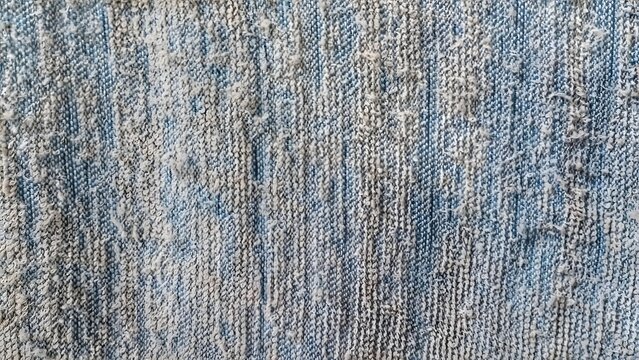 Close-up of a rugged blue-grey textured surface, showcasing worn fibers and an uneven, distressed appearance, creating a visually interesting background for abstract design projects