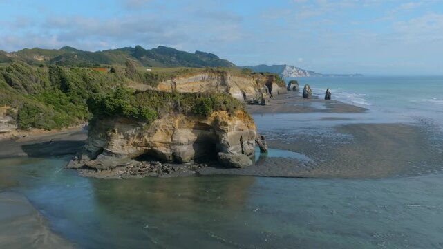 Coastal erosion forms cliffs and sea stacks at the remote, scenic, and ruggedly beautiful, Tongaporutu Beach in the Taranaki region of New Zealand. Tourists visit to explore.
