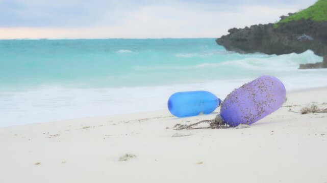 朝の美しい砂浜に打ち上げられた海洋ゴミとプラスチックブイ（スローモーション）