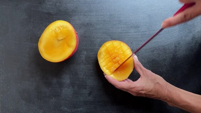 fast motion, female hand holding red knife cutting mango fruit in haf