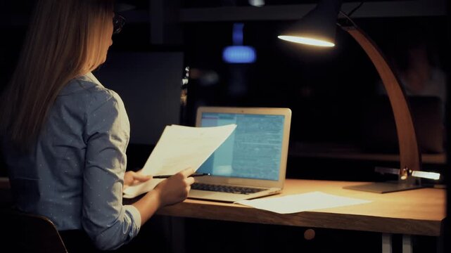 Office Worker Working Late at Night in Dark Office. Business Workflow and Overtime Tasks