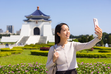 Naklejka premium Happy woman taking selfie at famous landmark in taipei