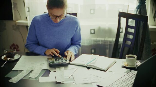 Calculating Finances and Expenses with Calculator and Bills. Home Office Accounting Workflow for Debt Management and Savings