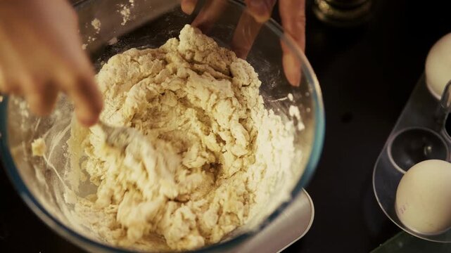 Kneading Raw Dough in Glass Bowl. Preparing Bread or Pizza.    Culinary Workflow with Flour and Yeast Mixture