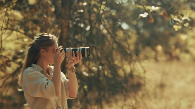 Photographer Taking Pictures with Digital Camera and Telephoto Lens. Creative Specialist Capturing Nature in Autumn Forest.  Outdoor Photography Session 