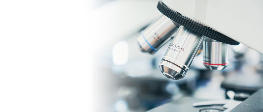a close up view of a laboratory microscope with a white background and lab.
