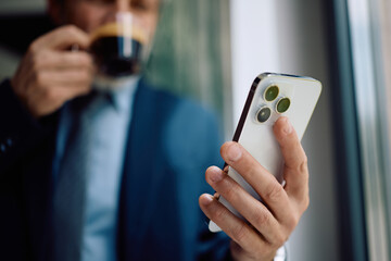 Fototapeta premium Close up of businessman using smart phone in office.