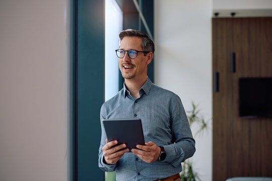 Happy entrepreneur using touchpad while working in office.