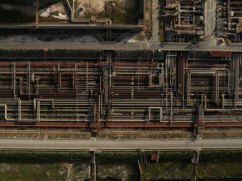 Aerial view of the intricate network of industrial pipelines and infrastructure at a refinery facility in Priolo Gargallo, Sicily, Italy.