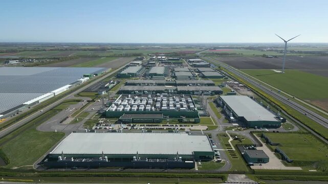 Drone footage showing a massive hyperscale data center complex surrounded by farmland and highways in the Netherlands.