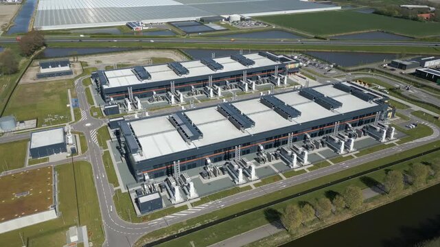 Low aerial drone footage capturing cooling systems and industrial infrastructure of a large scale data center facility.