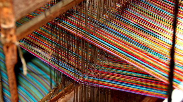 Close up view of Craftsmanship in Progress Bright Multicolored Threads on a Traditional Weaving Loom. vibrant array of multicolored threads.