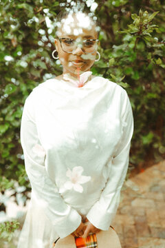 Double exposure image of a black woman in a floral garden setting