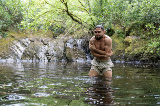 Man shivering in cold water during outdoor nature immersion