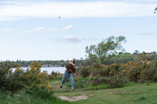 Man enjoying recreational activity throwing ball outdoors