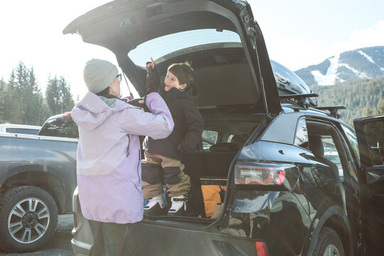 Mother helping her excited son get ready to ski