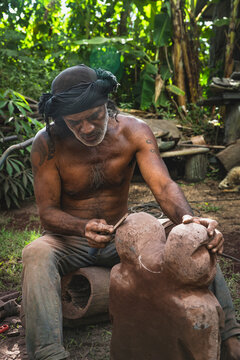Skilled artisan carves a stone figure outdoors