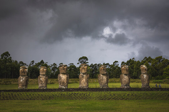 Easter Island Moai statues stand under dramatic stormy clouds