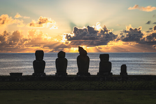 Silhouettes of Moai statues at sunset on Easter Island
