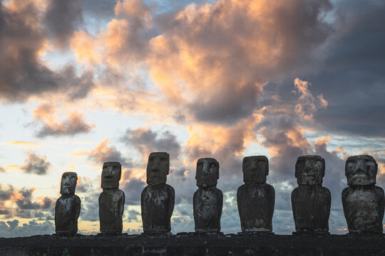 Easter Island Moai statues under dramatic sunset clouds
