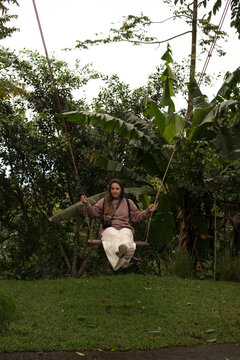 Young woman swinging on garden swing, Munduk Moding Plantation, Bali
