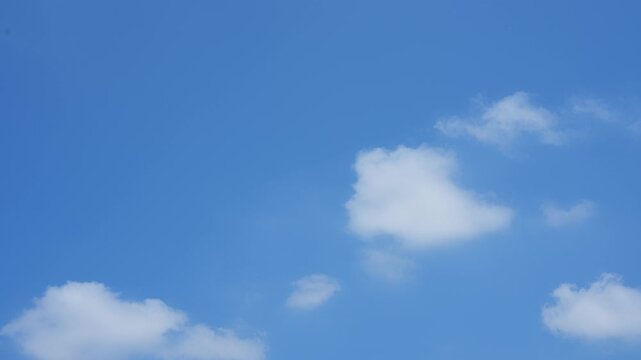 A blue sky timelapse video footage featuring soft white clouds slowly drifting across a clear sky, creating a peaceful daylight atmosphere with natural motion, calm weather, scenic outdoor beauty. 4k.