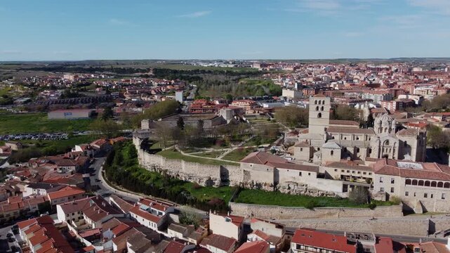 4K drone orbiting the historic medieval center of Zamora, Spain. Aerial view of the iconic Romanesque Cathedral, ancient stone walls, and castle ruins on a bright sunny day
