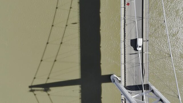 Drone flies backwards in bird's eye view of Samora Machel Bridge and its shadow on the Zambezi River on a sunny day in Tete, Mozambique