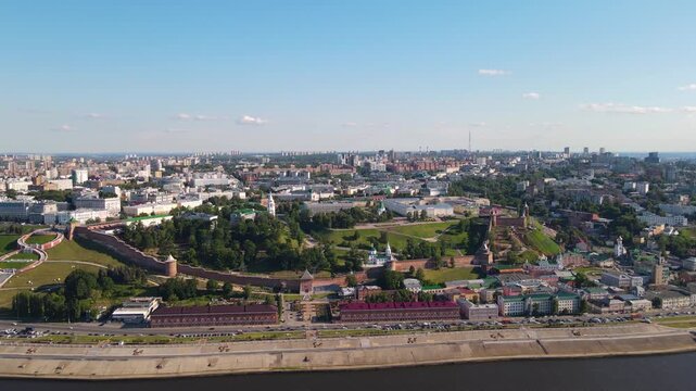 Cinematic aerial orbit shot of the Nizhny Novgorod Kremlin fortress with ancient walls and towers on the hill overlooking the city panorama