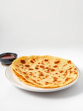 Golden brown paratha served on a plate against a clean white background, culinary, meal