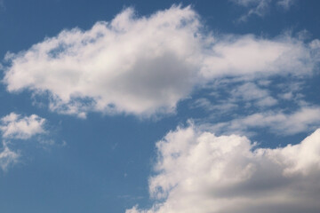 Fototapeta premium Fluffy white clouds in a bright blue summer sky background