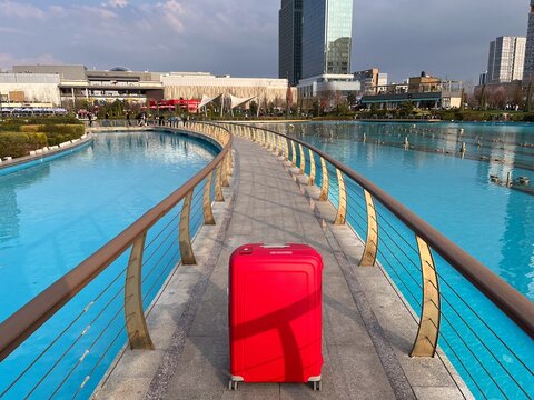 Red suitcase standing on bridge in modern tashkent city park