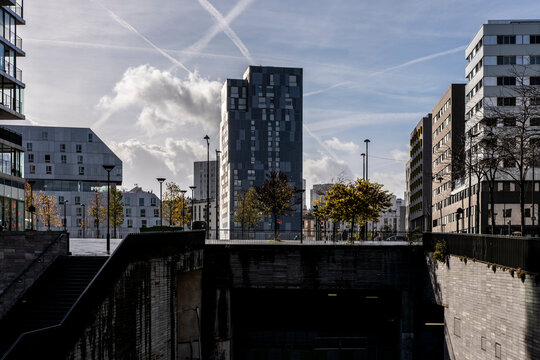 From a shadowed underpass, Rive Gauche in Paris appears through residential buildings, tower blocks and a narrow urban street passage.