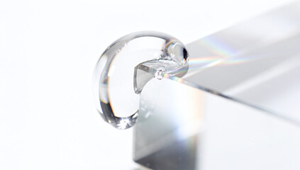 Fototapeta premium Water drop on glass prism white background horizontal