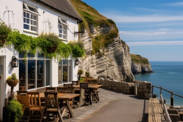 Naklejka premium Restaurant patio offering outdoor dining with stunning views of the sea and jurassic coast cliff