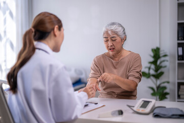 Obraz premium Senior woman discussing arm pain with doctor
