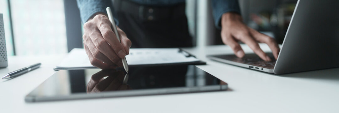 Corporate analyst sitting at desk with audit papers, financial ledger and calculator in business environment