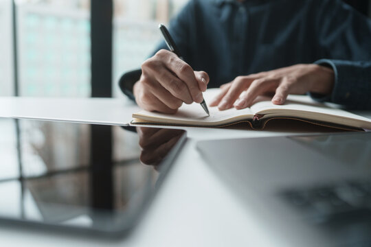 Office administrator reviewing audit documents on table with calculator and financial file folders