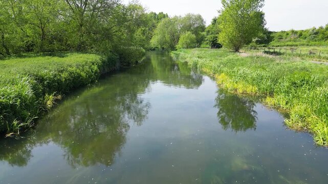 Low Forward Drone Tracking Shot Over Calm Reflective River Stour Lush Green Banks Hambrook Marshes Canterbury Kent