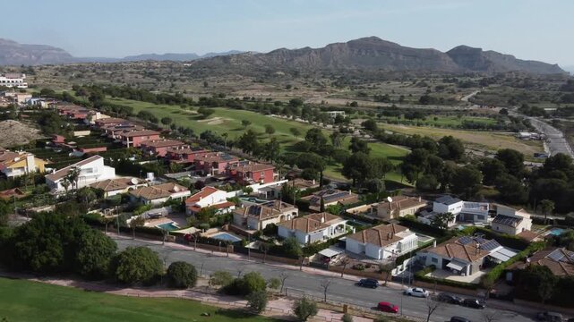 Aerial view of villas on the front row of the Alenda golf course, with mountain ranges in the background. Alicante, Spain.