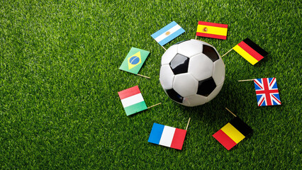 Soccer ball on a football field surrounded by international flags. Concept of global football world cup, international teams, competition and world championship. Top view, flat lay. © PixelArt_25
