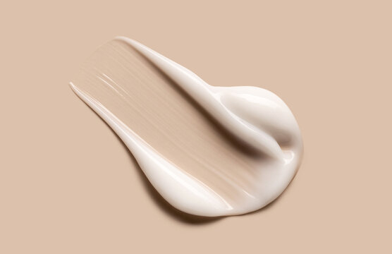 cosmetic smear of creamy texture on a pastel beige background