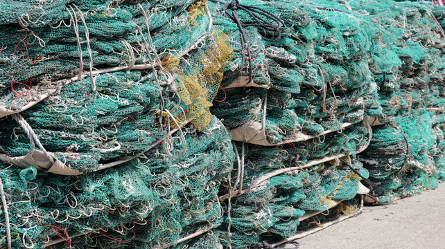 Stacked Commercial Green Fishing Nets on Dock