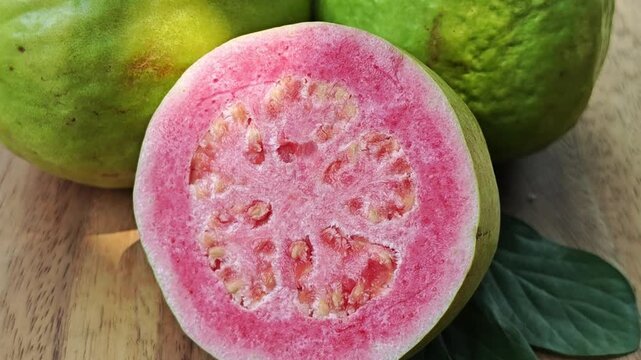 Pink guava on wooden board. Zoom out.