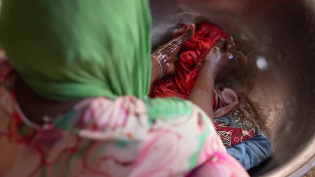 Close up of African woman hand washing clothes in basin, April 25, 2026, Chad, N Djamena